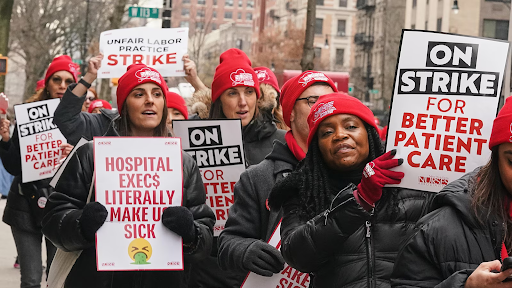  Nurses assemble outside of Mount Sinai Morningside Hospital to protest working conditions. Red attire and signs represent their membership in the New York State Nurses Association (NYSNA).  
