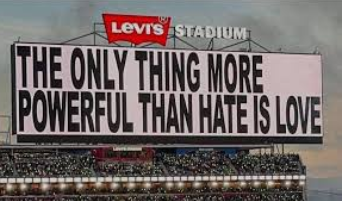 A billboard displayed during the Super Bowl LX Halftime show headlined by Bad Bunny reads “The only thing more powerful than hate is love.” 
