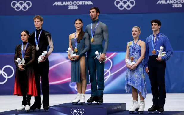 France, the United States, and Canada stand on the podium after the ice dance program in the 2026 Winter Olympics. Photo by Yara Nardi via REUTERS
